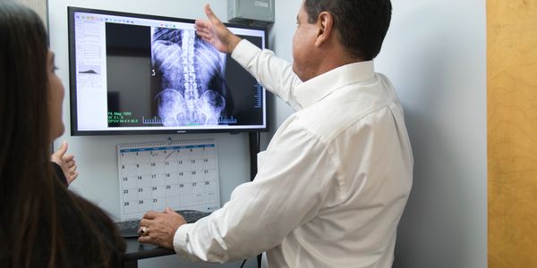 Chiropractor reviewing X-ray with patient