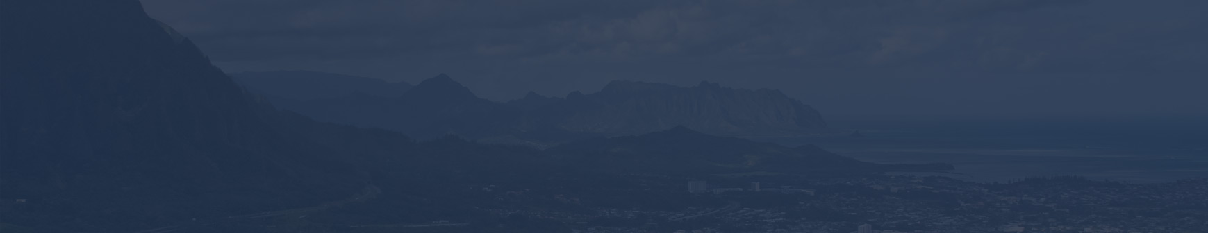 A dark sky with some mountains in the background